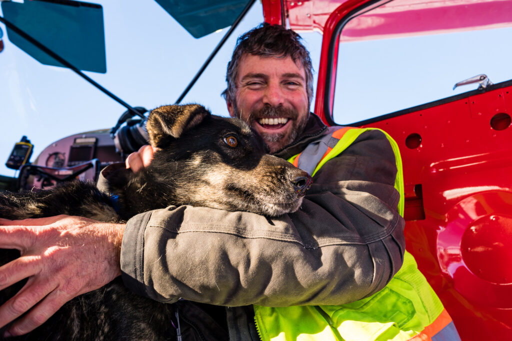 Iditarod Air Force pilot and a furry friend getting ready to leave the Rohn Checkpoint of the Iditarod.
